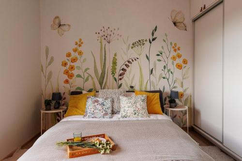 a bedroom with a bed with flowers on the wall at Stylowe apartamenty in Charzykowy