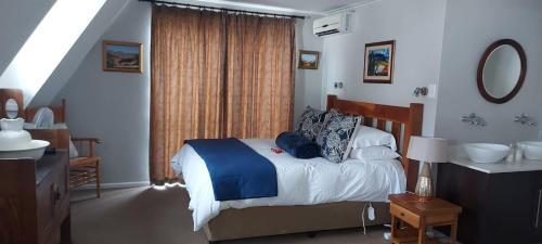 a bedroom with a bed and a bathroom with a sink at 13 on 2nd Hermanus in Hermanus