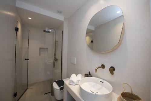 a white bathroom with a sink and a mirror at Summer Breeze Luxury Villa Mykonos in Mykonos