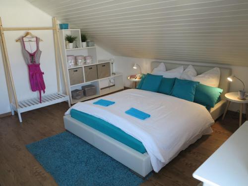 a bedroom with a bed with blue and green pillows at Allgäu Spirit in Immenstadt im Allgäu
