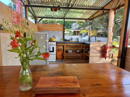 a vase of flowers on a wooden table in a kitchen at BIOSFERA LODGE GLAMPING tipi 2 personas in Oxapampa