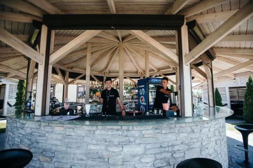 Tre persone in piedi in un bar in un padiglione di Chalet a Shypyntsi