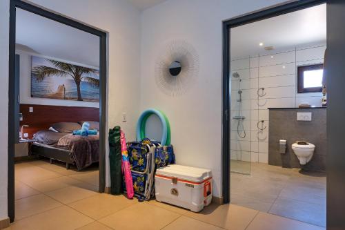 Habitación con baño con cama y espejo. en Bubali Luxury Apartments - Adults Only - Wheelchair Friendly, en Palm-Eagle Beach