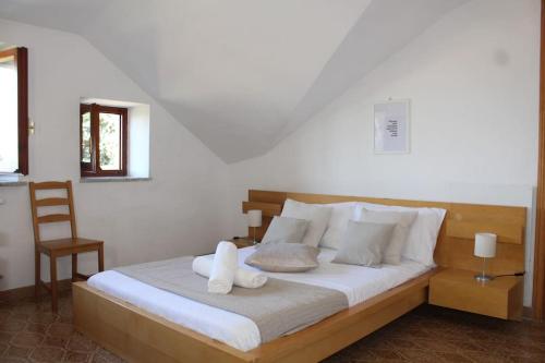 a bedroom with a bed with white sheets and a chair at Spazioso appartamento (FREE PARKING) in Castel di Leva