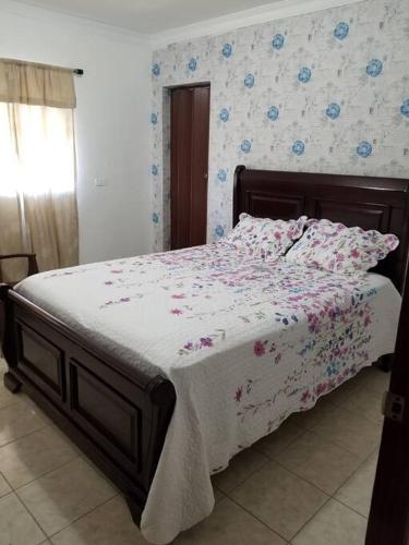 a bedroom with a bed with a floral bedspread at Apartamento acogedor con equipamiento premium in El Café