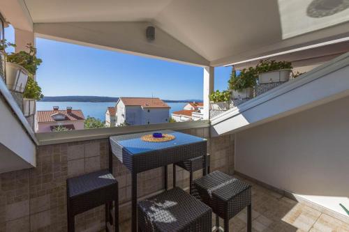 Un balcón con una mesa y sillas azules y una ventana grande. en Ivan & Anka apartments BOJKO, en Selce