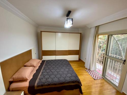 1 dormitorio con cama y ventana grande en Golden house - men only, en Seis de Octubre