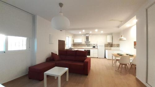 - un salon avec un canapé rouge et une table dans l'établissement Apartamento Alegría, à Frigiliana
