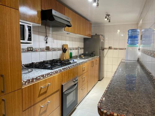 uma cozinha com armários de madeira e um forno com placa de fogão em La casa de Ely em Iquique