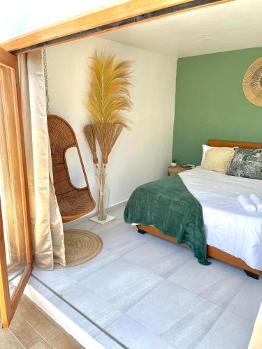 a bedroom with a bed and a palm tree at Moringa Resort with Pool, open Air Shower & shared Bath sleeps 8 in Willemstad