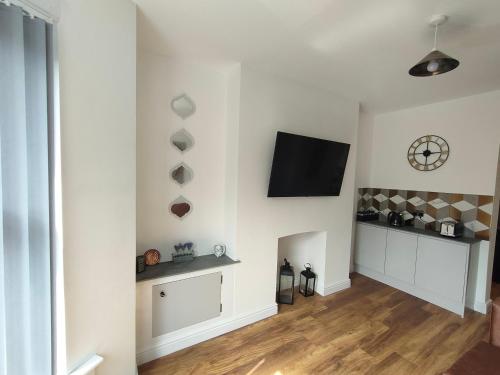 a living room with a flat screen tv on a wall at Lovely refurbished apartments, Morecambe Promenade in Morecambe