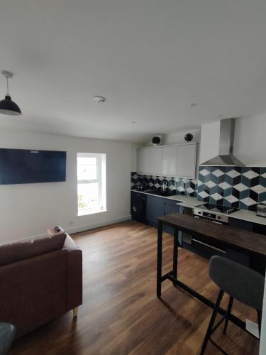a living room with a couch and a table at Lovely refurbished apartments, Morecambe Promenade in Morecambe