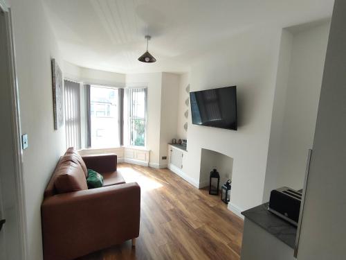 a living room with a couch and a flat screen tv at Lovely refurbished apartments, Morecambe Promenade in Morecambe