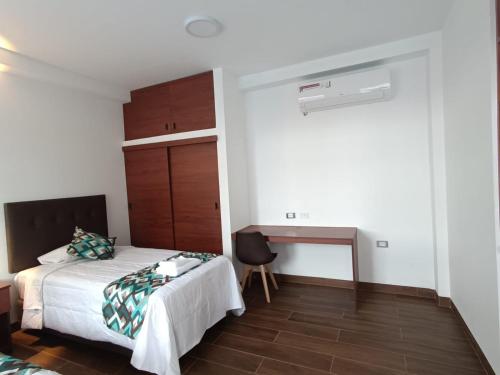 a bedroom with a bed and a desk in it at Hotel El Bosque in Jaén