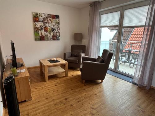 a living room with two chairs and a television at Businesswohnungen Haag bei A7 in Aalen