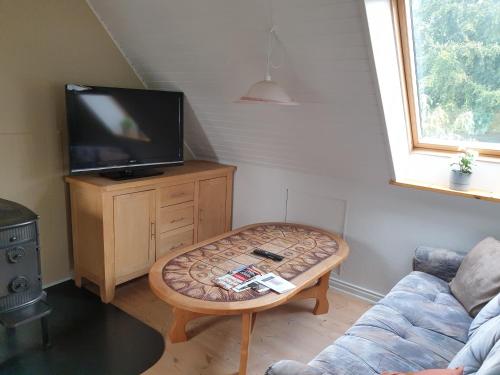 a living room with a couch and a coffee table at Lejlighed vest for Christiansfeld in Christiansfeld