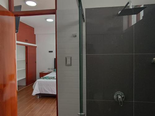 a bathroom with a shower and a bedroom with a bed at Hotel El Bosque in Jaén