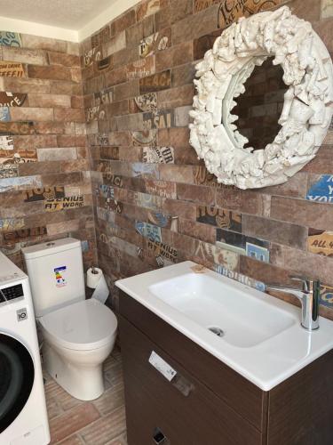 a bathroom with a sink and a toilet and a mirror at A Casa Azul in Santa Luzia