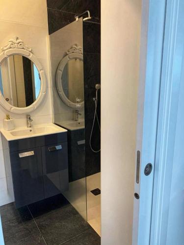 a bathroom with two sinks and a shower with two mirrors at A Casa Azul in Santa Luzia