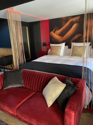 - une chambre avec un lit et un canapé rouge dans l'établissement Suite Gatsby - balançoire et baignoire duo - Luxe et charme - climatisation, à Eyrans-de Soudiac