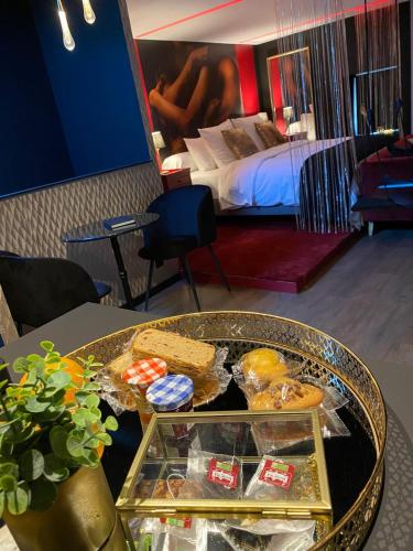- une table avec un plateau de nourriture dans une chambre d'hôtel dans l'établissement Suite Gatsby - balançoire et baignoire duo - Luxe et charme - climatisation, à Eyrans-de Soudiac