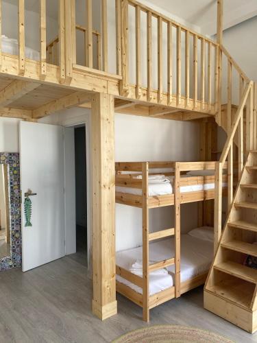 a loft bed with a staircase in a room at A Casa Azul in Santa Luzia