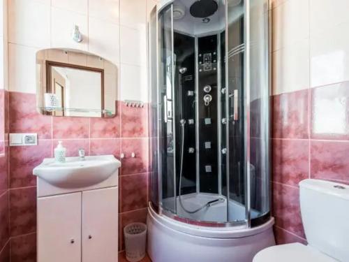 y baño con ducha y lavamanos. en Villa Trylogia en Mielno