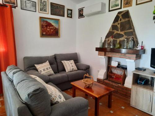 a living room with a couch and a fireplace at CASA GASPAR, alojamiento rural con vistas al mar en paraje natural in Granada