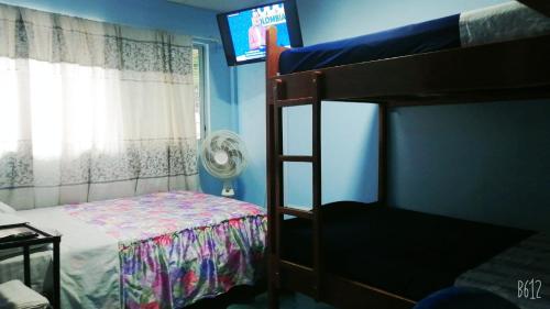 um quarto com um beliche e uma televisão de ecrã plano em Hostal Aruba em Atacames