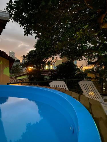 a blue table and chairs with a sunset in the background at Ateliê 22 in Natal