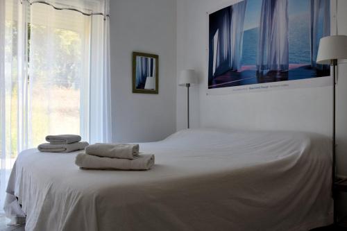 une chambre blanche avec un lit avec des serviettes dessus dans l'établissement U Pianarellu, à Olmeto