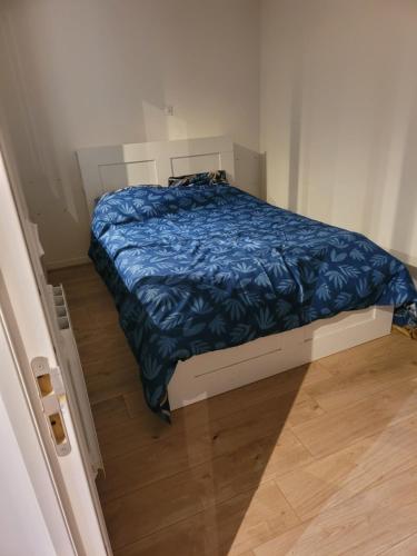 - une petite chambre avec un lit et une couette bleue dans l'établissement Loft hyper centre confortable et agréable, à Lille