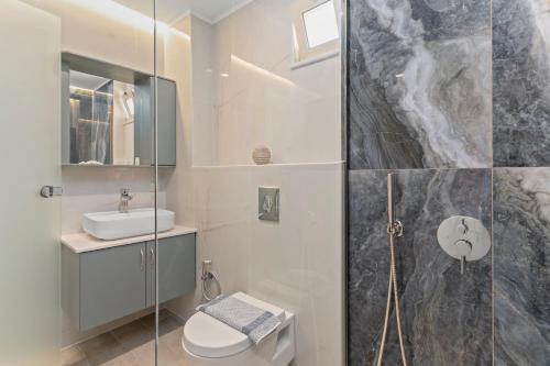 ein Bad mit einer Dusche, einem WC und einem Waschbecken in der Unterkunft Mathios apartments Falassarna in Phalasarna