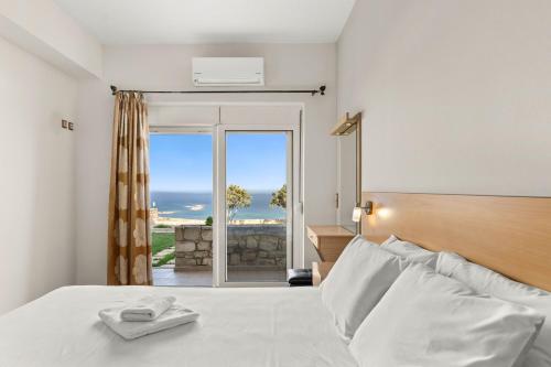 a bedroom with a bed with a view of the ocean at Mathios apartments Falassarna in Falasarna