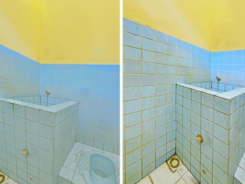 uma casa de banho com um urinol e uma parede de azulejos azuis em SPOT ON 91372 Wisma Bulin em Purwokerto