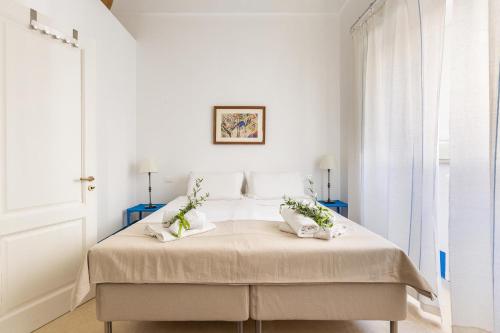 a white bedroom with a bed with two pillows at Dimora Blu by BarbarHouse in Cerfignano