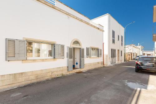 a car parked on a street next to a white building at Dimora Blu by BarbarHouse in Cerfignano