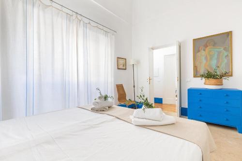 a white bedroom with a large bed and a blue dresser at Dimora Blu by BarbarHouse in Cerfignano
