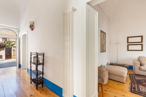 a living room with white walls and a blue stripe on the wall at Dimora Blu by BarbarHouse in Cerfignano
