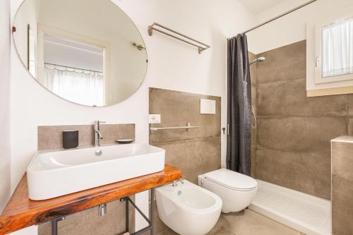 a bathroom with a sink and a toilet and a mirror at Dimora Blu by BarbarHouse in Cerfignano