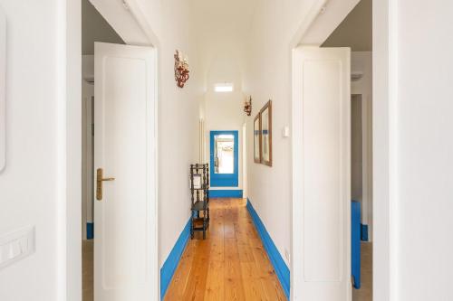 a hallway with blue and white walls and wood floors at Dimora Blu by BarbarHouse in Cerfignano