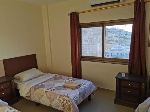 1 dormitorio con cama y ventana en Petra Gate Hotel, en Wadi Musa