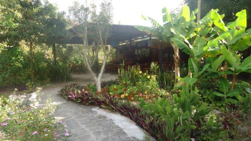 a garden with flowers and plants in front of a building at Pousada Aba da Serra in São Joaquim do Monte