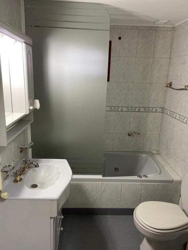 a bathroom with a sink and a toilet and a tub at BE MAISON USHUAIA in Ushuaia