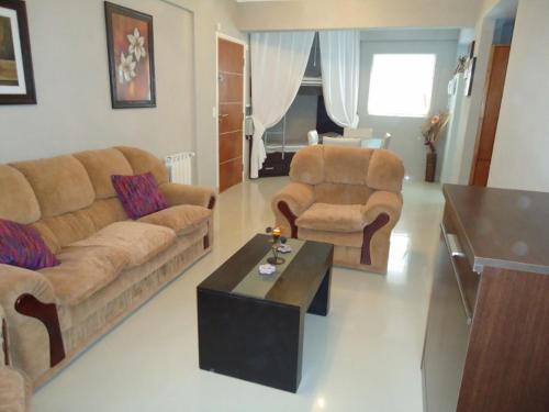Sala de estar con 2 sofás y mesa de centro en el Departamento Huarpes en Villa Gesell