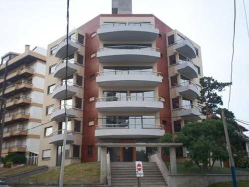 un edificio de talla con escaleras frente al Departamento Huarpes en Villa Gesell