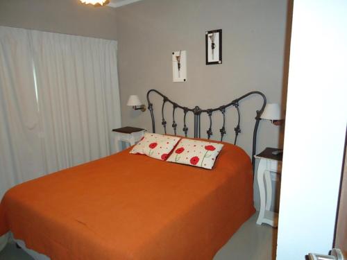 1 dormitorio con 1 cama con 2 almohadas en Departamento Huarpes en Villa Gesell