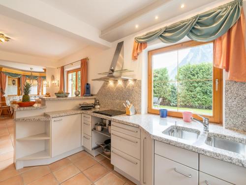 a kitchen with a sink and a large window at Charming holiday home in Maurach am Achensee in Maurach