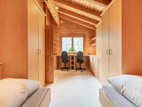 sypialnia z 2 łóżkami i biurkiem z 2 krzesłami w obiekcie Charming holiday home in Maurach am Achensee w mieście Maurach