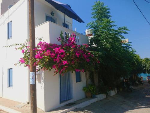 una casa con flores rosas a un lado. en ~~ Sea Breeze covered house ~~, en Mókhlos